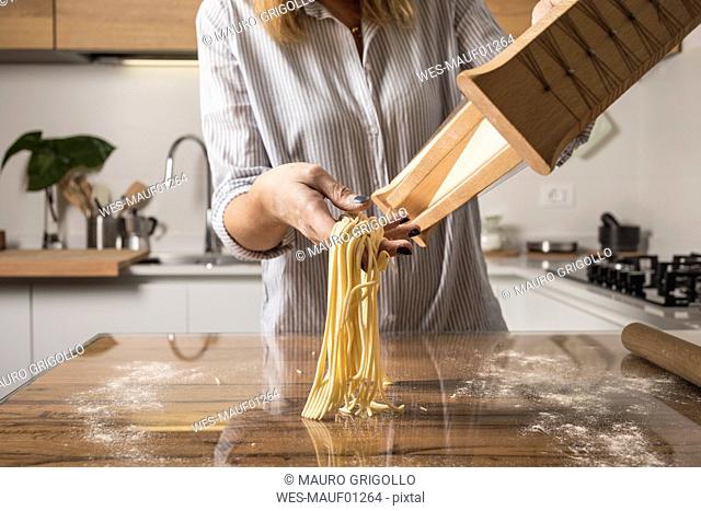 Woman preparing homemade pasta, row noodles, pasta harp