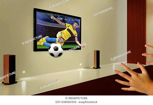 Caucasian soccer player coming out of television set