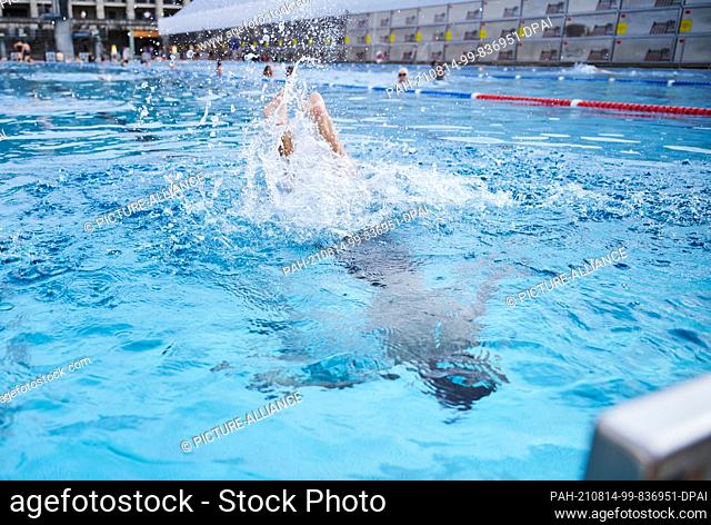 13 August 2021, Berlin: A child jumps into the pool at the Olympiastadion summer pool. Summer temperatures are expected in Berlin this weekend