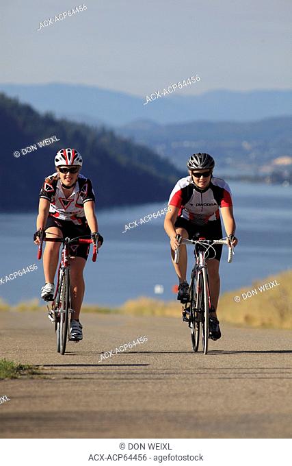 Teenage females cyclists over looking Kalamalka Provincial Park, near Vernon, Okanagan, British Columbia, Canada