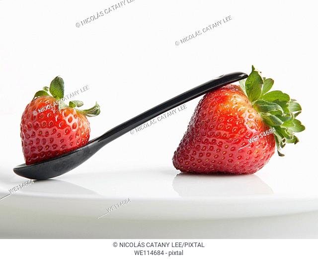 Still life photograph with strawberries and a spoon indicating healthy food