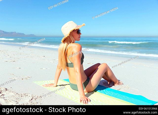 Woman sitting on the towel at the beach
