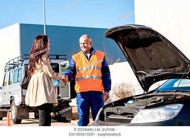 Woman shaking hands with mechanic car breakdown