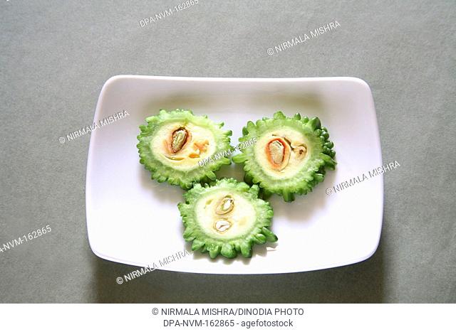 Green vegetables , slices of karela bitter gourd momordica charantia in rectangle plate on grey background