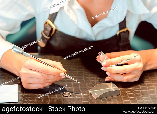 Jeweler sorting diamonds with pincers