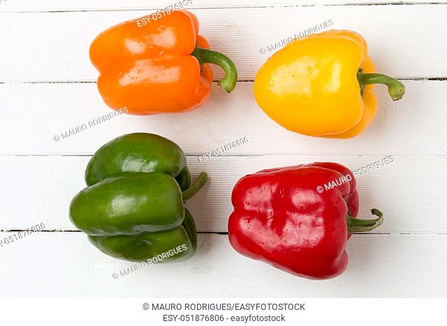 Fresh and colorful bell peppers on a white wooden background