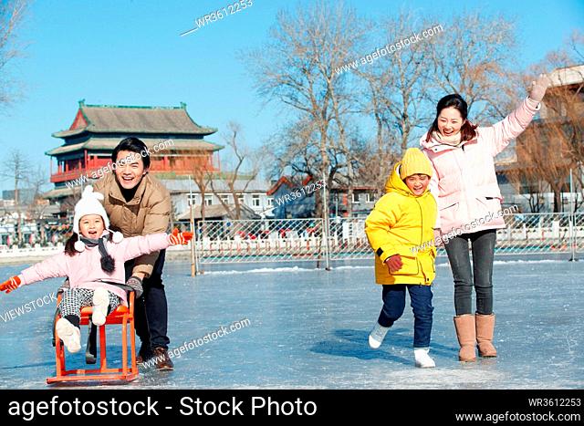 A family of four play in the skating rink