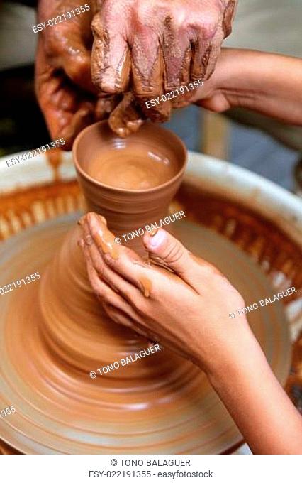 craftsman potter hands of teacher and pupil clay pottery
