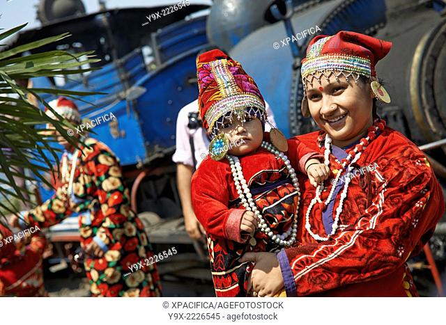 Indian tourists in traditional clothing pose on the tracks of The Darjeeling Himalayan Railway, also known as the ""Toy Train""