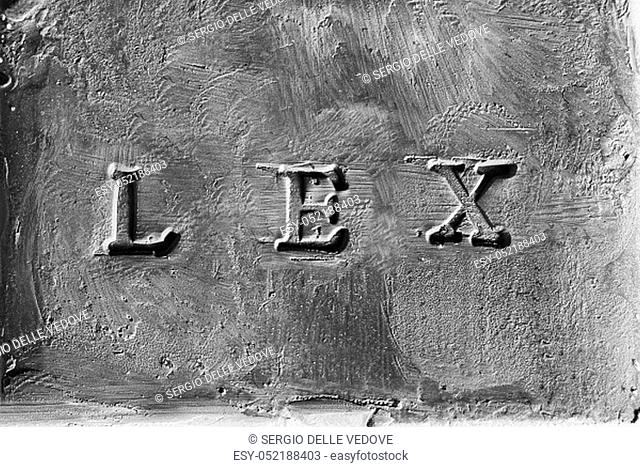 the Latin word Lex engraved on a rough surface