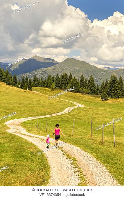 Mom with her daughter runs on the Non valley paths, Cles, Trento province, Trentino Alto Adige, Italy, Europe (MR)