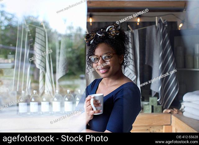 Portrait confident female shop owner drinking tea