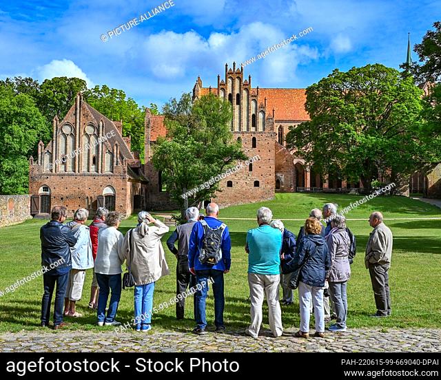 14 June 2022, Brandenburg, Chorin: A group of visitors stands in Chorin Monastery. The history of Chorin Monastery goes back a long time