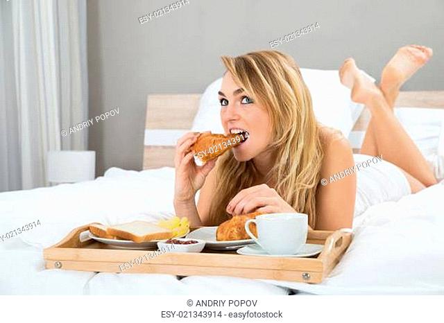 Photo Of Young Woman Having Breakfast In Bedroom