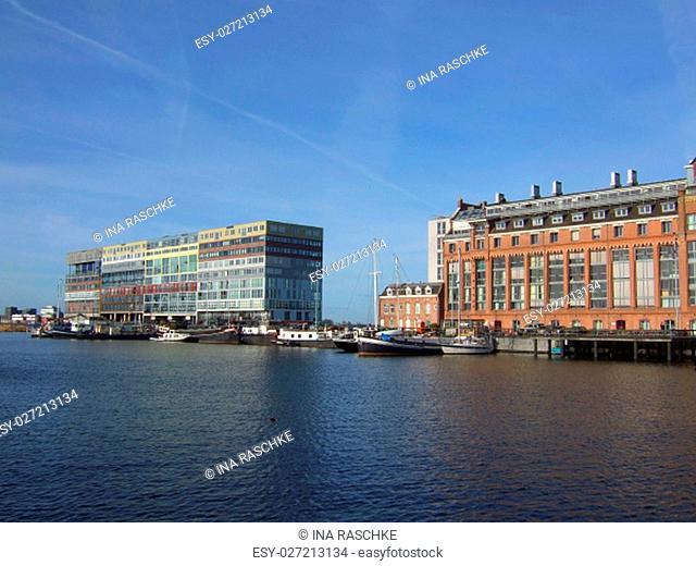 Silodam building and grain silo in Amsterdam port, Netherlands. Silodam, a colorful cubic block containing 157 apartments (privately owned and rental)