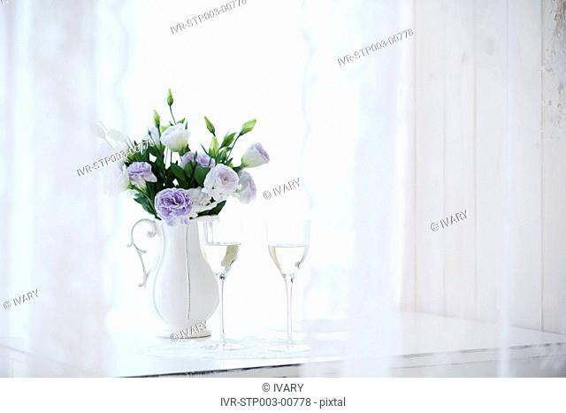 Close-up of wine glasses with flower vase