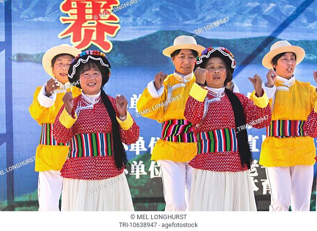 Mosuo women dancing, wearing traditional costume, Lijiang, Yunnan Province, China