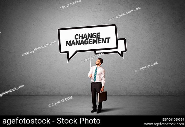 Young business person in casual holding road sign with CHANGE MANAGEMENT inscription, new business idea concept