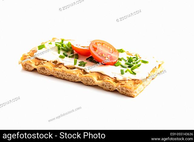 Crispbread with creamy cheese, chive and cherry tomatoes isolated on white background