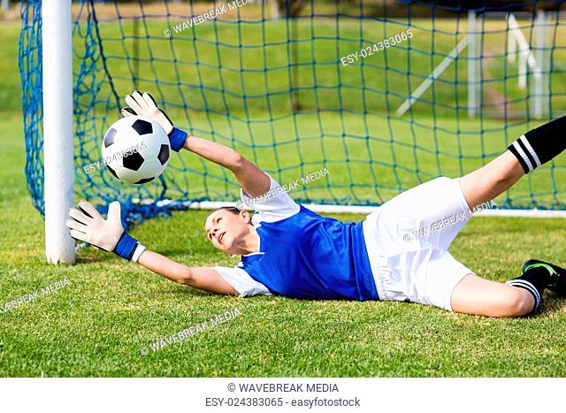 Female goalkeeper saving a goal