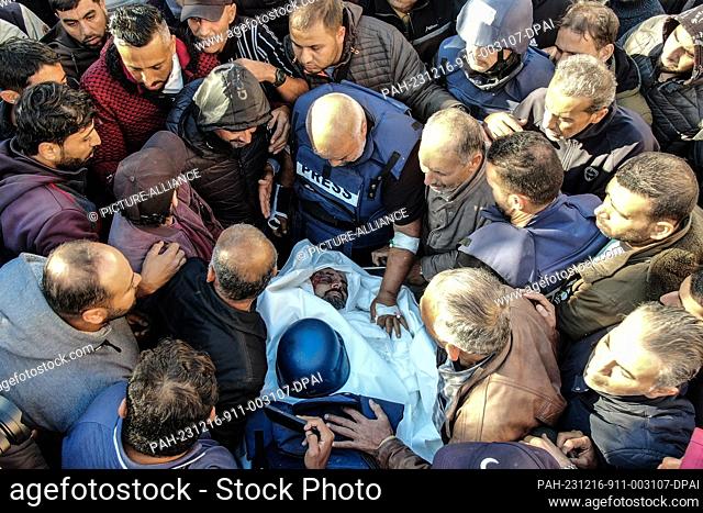 16 December 2023, Palestinian Territories, Khan Yunis: Palestinian mourn the body of Al Jazeera cameraman Samer Abu Daqqa during his funeral in the vicinity of...
