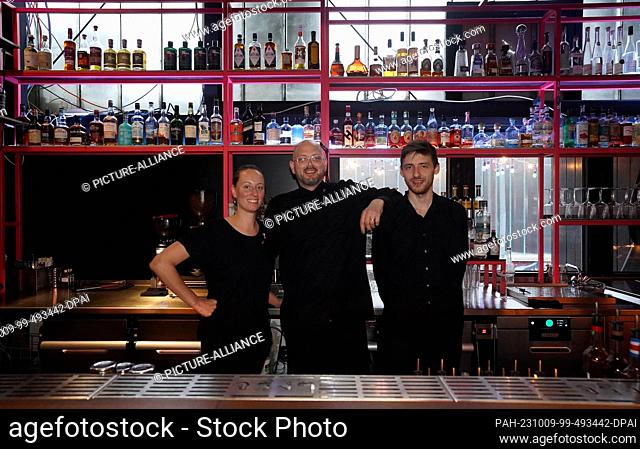 07 October 2023, Hamburg: Frederik Schefferski (m), bar manager at the Thai food bar ""Jing Jing, "" stands between bartenders Lorena Böhm (l) and Finn Kluth...