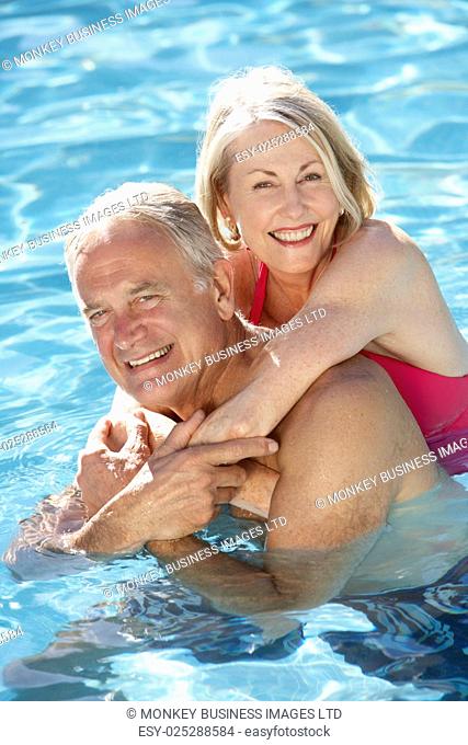 Senior Couple Relaxing In Swimming Pool Together