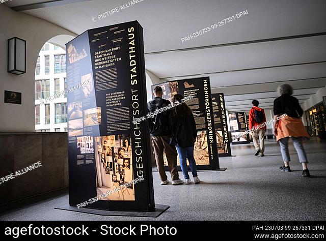 03 July 2023, Hamburg: Visitors stand at text panels in a public passageway at the Stadthaus History Site. The Stadthaus History Site was transferred to the...