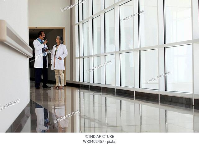 Two doctors talking in hospital corridor