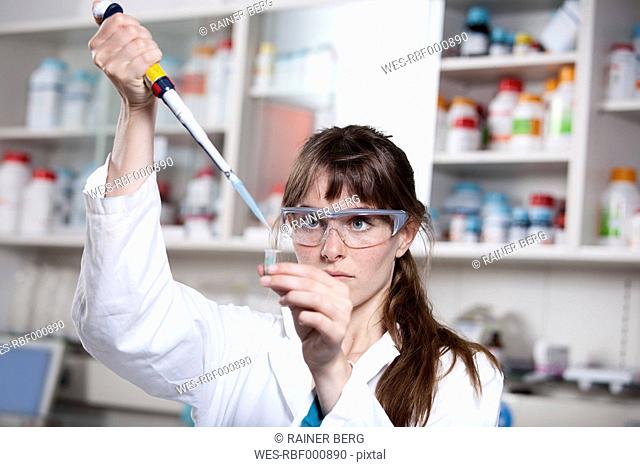 Germany, Bavaria, Munich, Scientist with pipette and test tube in laboratory