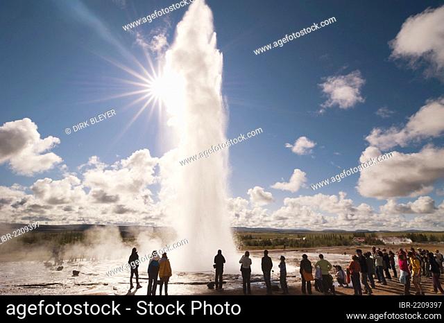 Tourists watching steam and a water spout, Strokkur geyser, backlit, Haukadalur valley, Golden Circle, Suðurland, Sudurland, southern Iceland, Iceland, Europe