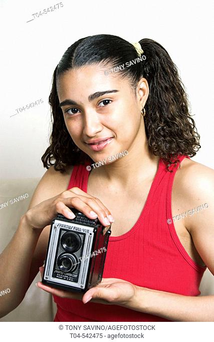 25-year-old Dominican woman holding antique camera