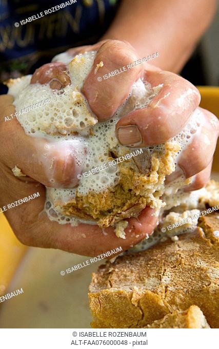 Squeezing excess milk from bread