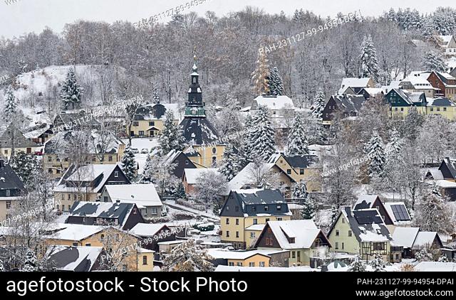 27 November 2023, Saxony, Seiffen: Snow covers the roofs of the toy village of Seiffen with its characteristic mountain church
