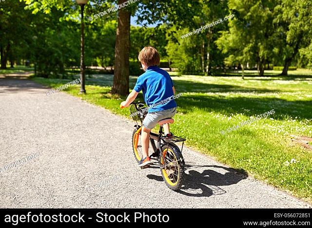 little boy riding bicycle at summer park