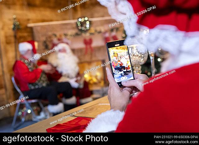 21 October 2023, Lower Saxony, Celle: A participant of a Santa Claus training session films with a smartphone during the training