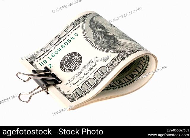 The American dollar bills are folded and clamped with a paper clip. on white background