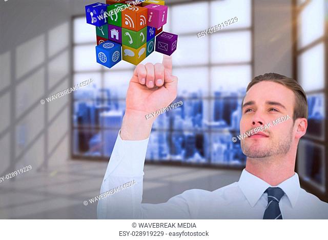 Composite image of cheerful businessman pointing cube with his finger