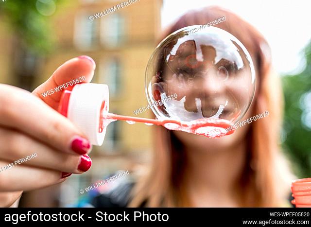 Young woman showing soap bubble