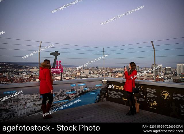 15 January 2022, Slovakia, Bratislava: A woman takes a photo of another woman on a platform of the Ufo observation tower