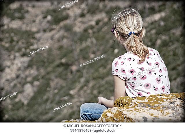 Blonde girl teen, back looking at the landscape in Gátova, Valencia, Spain
