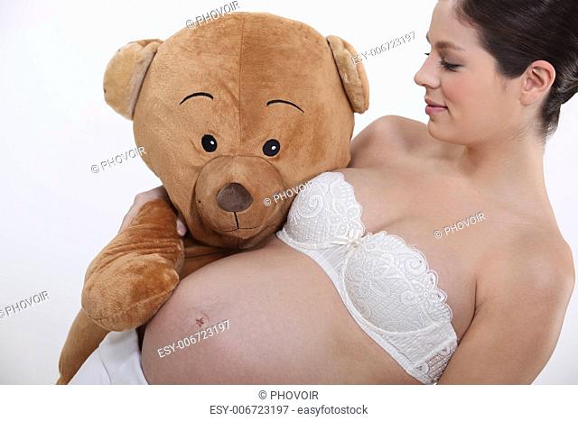 Pregnant woman holding a giant teddy bear