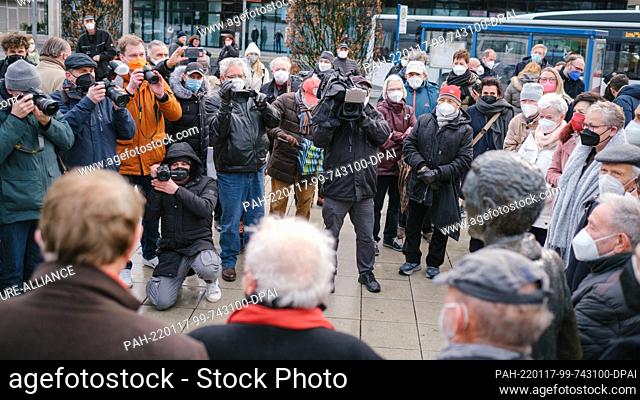 17 January 2022, Lower Saxony, Wolfsburg: Media representatives crowd around the monument to the Italian immigrants, ""L'Emigrante"" by artist Quinto...