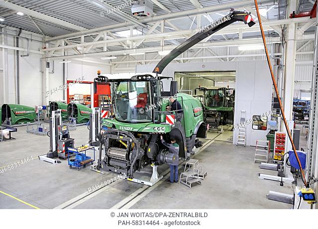 Two employees mount a Fendt Katana 65 corn chopper in a former tank maintenance hall in Hohenmoelsen, Germany, 17 April 2015