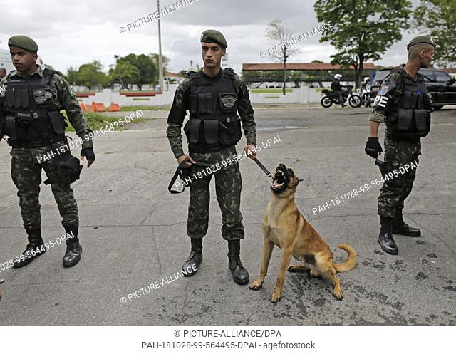 28 October 2018, Brazil, Rio de Janeiro: Soldiers guarding a polling station with a service dog. The presidential election has begun in Brazil