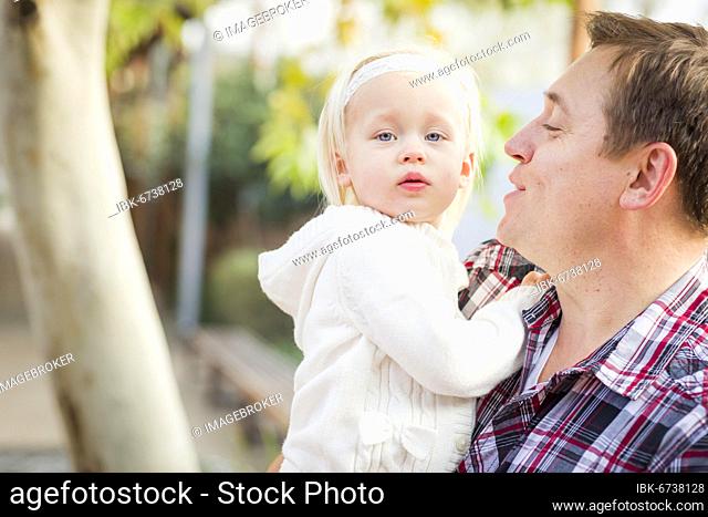 Adorable little girl with her daddy portrait outside