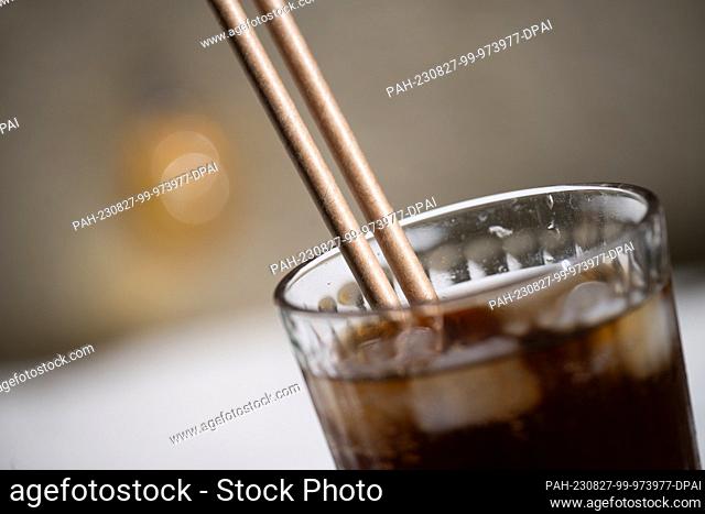 PRODUCTION - 24 August 2023, Berlin: Paper straws stuck in a glass of lemonade. Instead of the banned plastic straws, many restaurants now offer paper straws