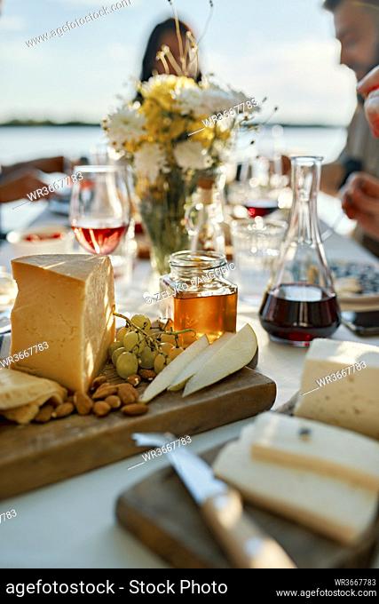Cheese platter on table with people in background