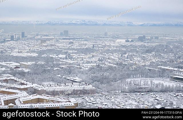 04 December 2023, Bavaria, Munich: The snow-covered city can be seen from a high-rise building. The Alps can be seen in the background