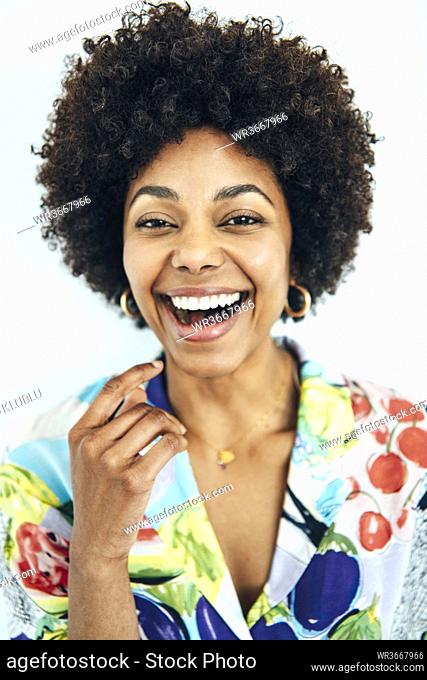 Cheerful mid adult woman with afro hairstyle against white background